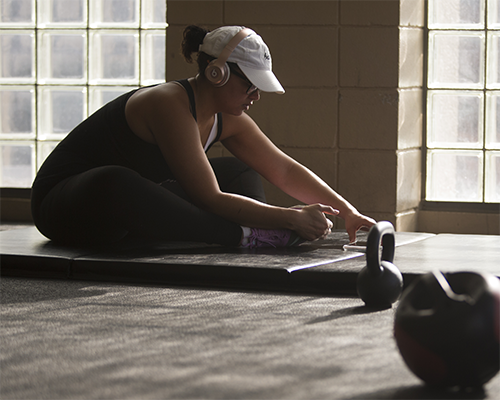 Student on phone at indoor track.