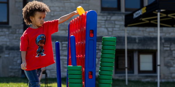 Young boy playing yard games.