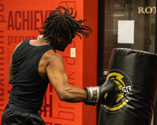 Student hitting boxing equipment,