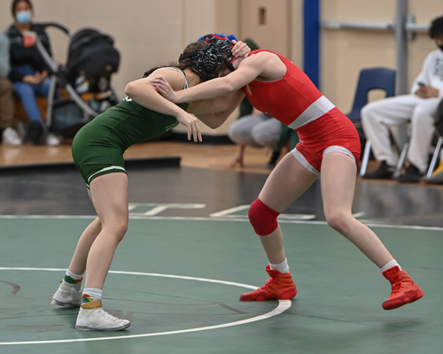 Two women wrestling at the beginning of a match.